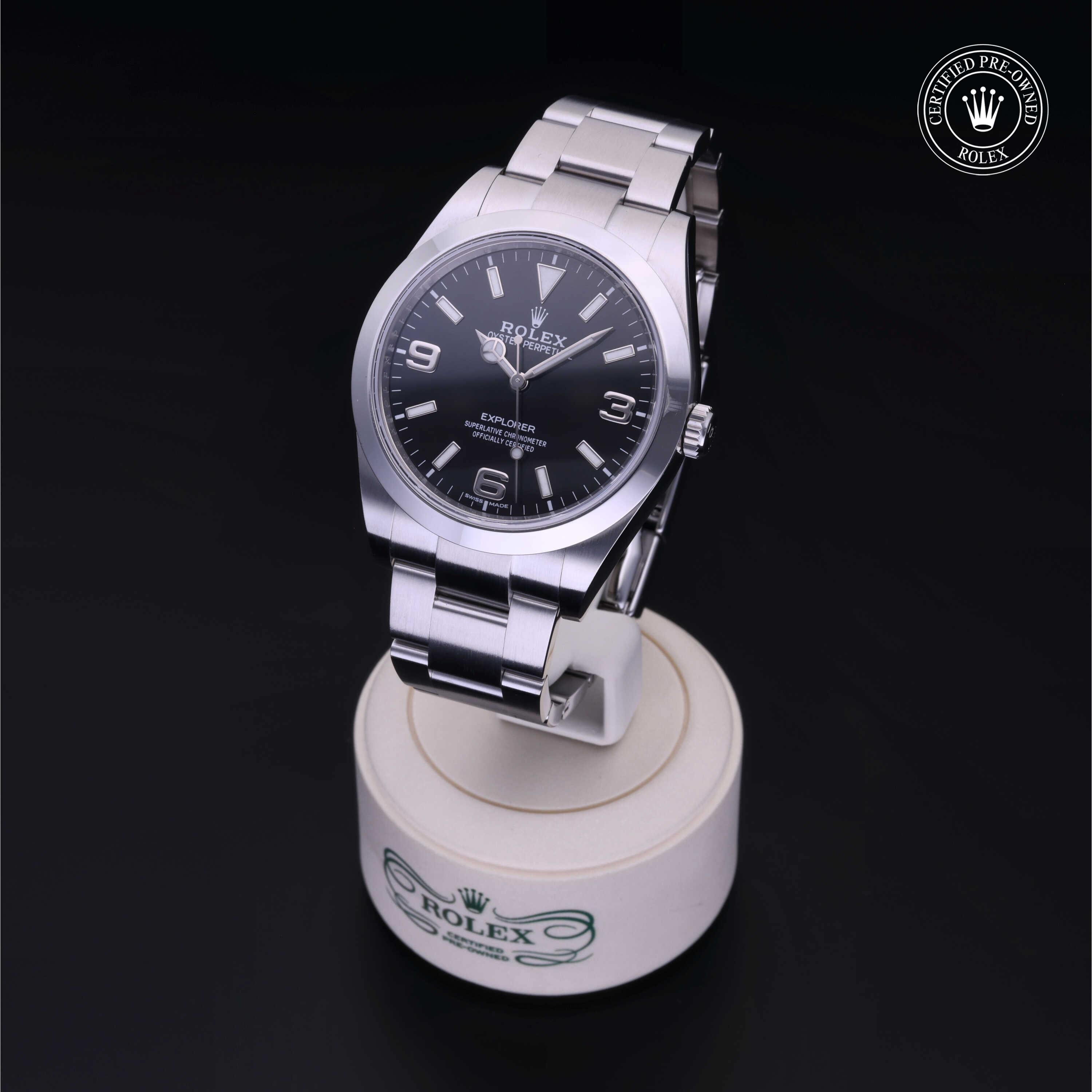 Rolex stainless steel watch with black dial displayed on a stand, featuring Rolex Certified Pre-Owned logo in the corner, highlighting luxury watch expertise.