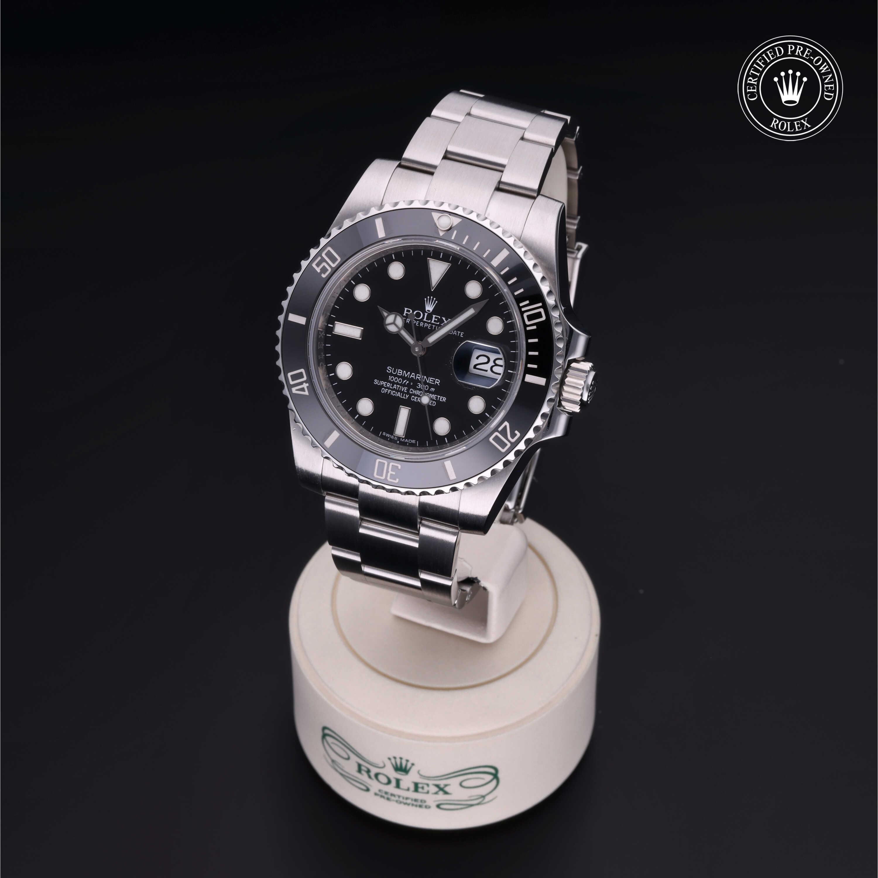 Close-up of a luxury Rolex Submariner watch with a black dial and stainless steel band displayed on a white stand with the Rolex logo, highlighting precision and elegance.