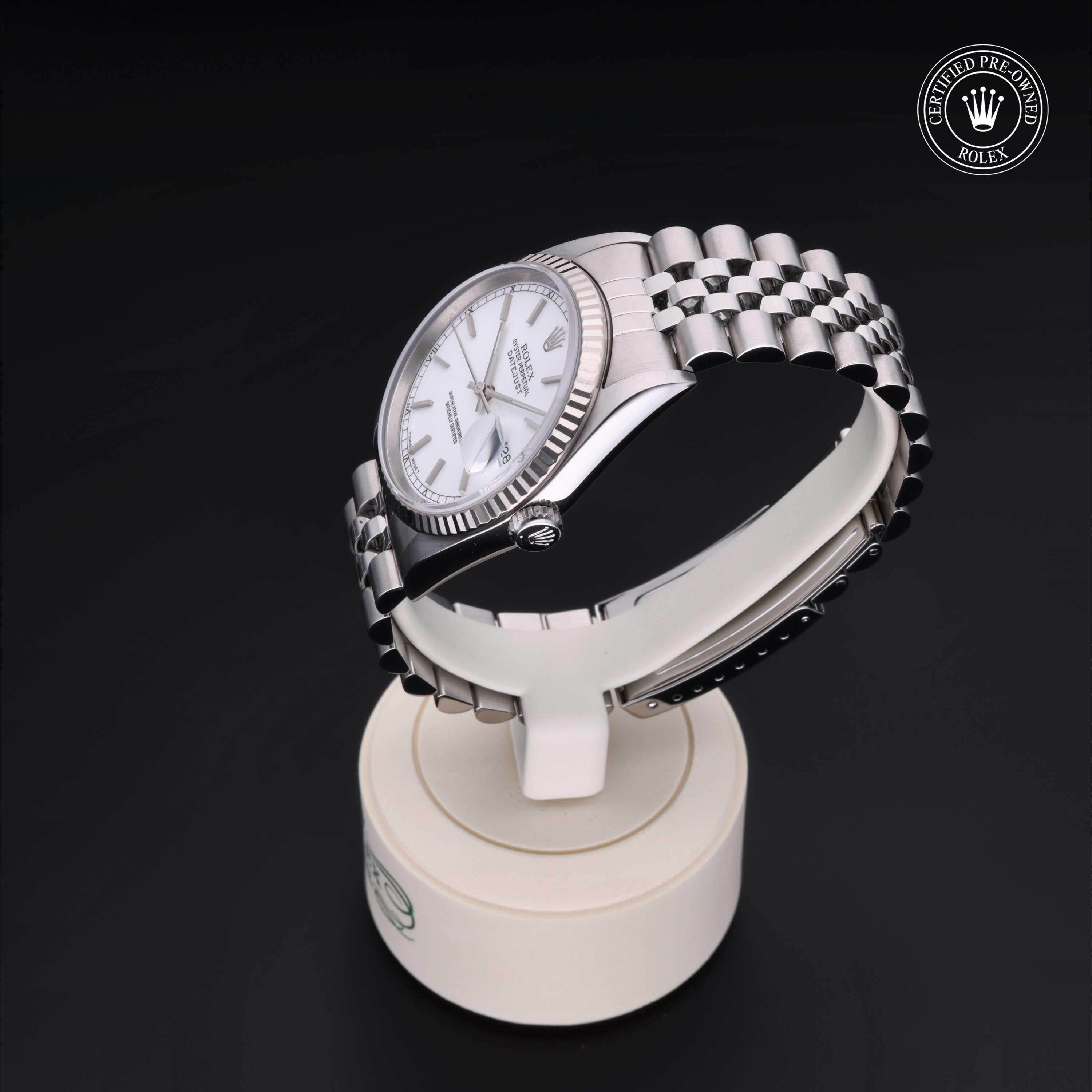 Silver Rolex watch with a white dial and fluted bezel displayed on a white stand, featuring a stainless steel Jubilee bracelet and Rolex Certified Pre-Owned logo.