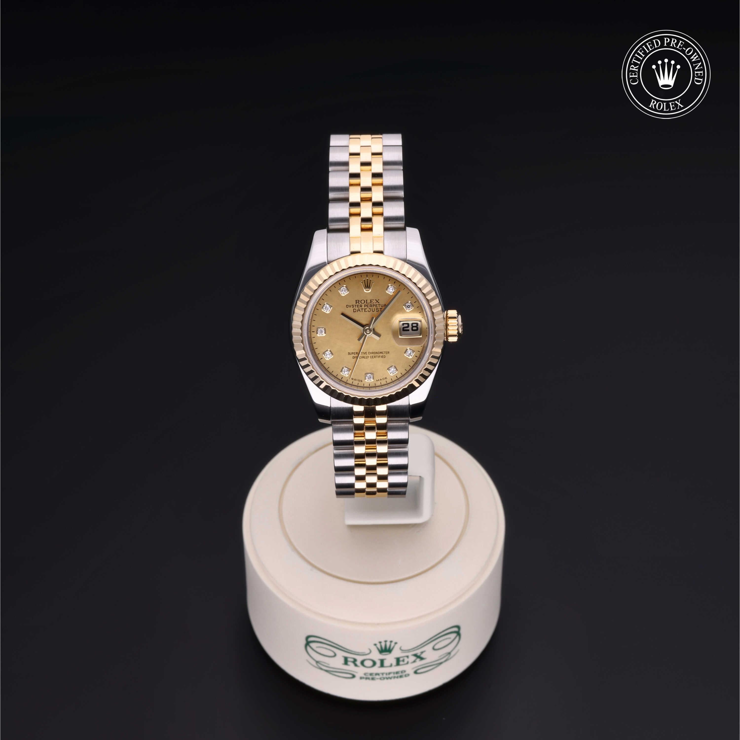 Rolex two-tone luxury watch with gold dial and diamond hour markers displayed on a branded stand, emphasizing fine craftsmanship and certified pre-owned quality.