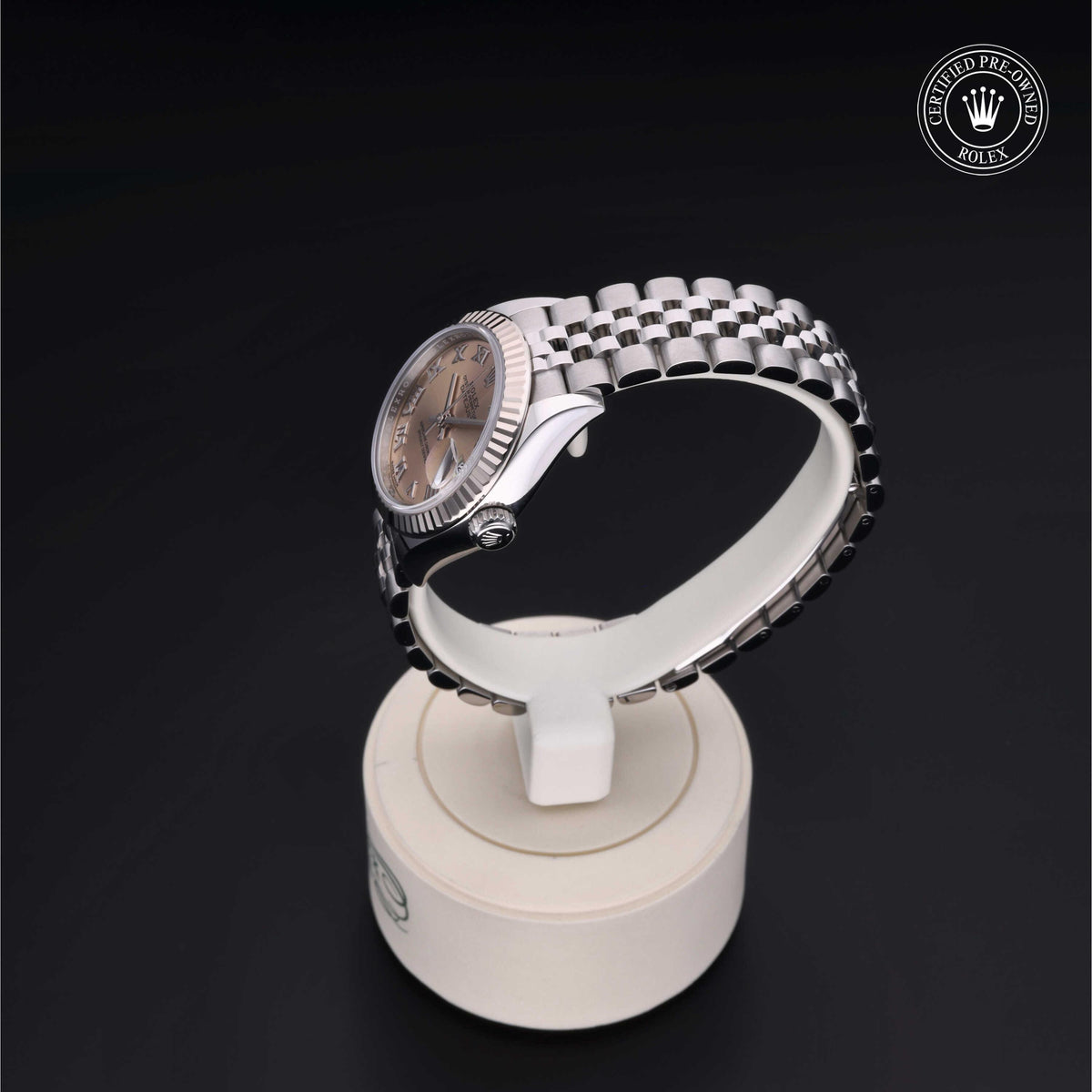 Stainless steel Rolex watch with a silver dial and Jubilee bracelet displayed on a white stand against a dark background with a Certified Pre-Owned Rolex emblem.