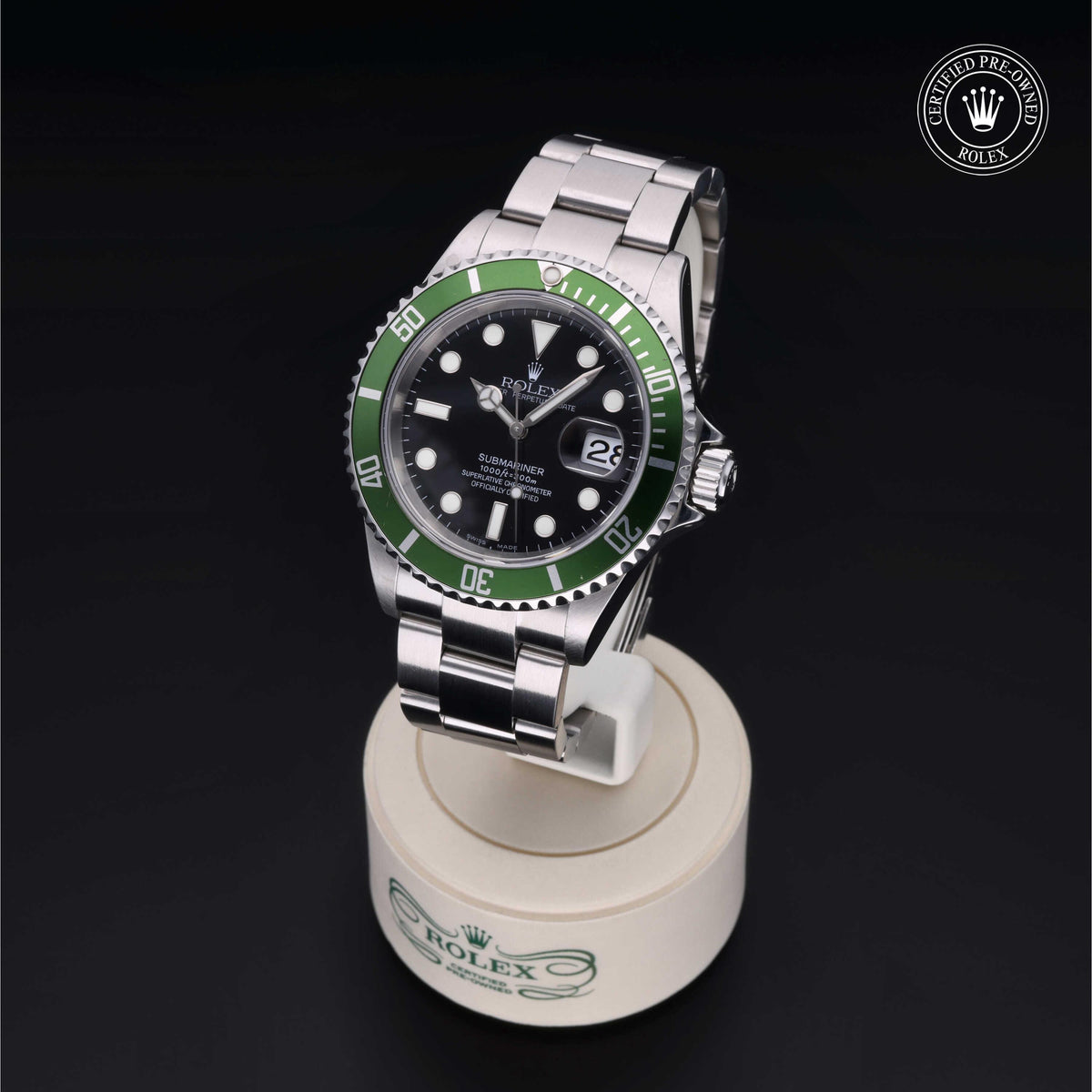 Rolex Submariner watch with a green bezel and black dial displayed on a branded stand with a Certified Pre-Owned Rolex logo in the background.