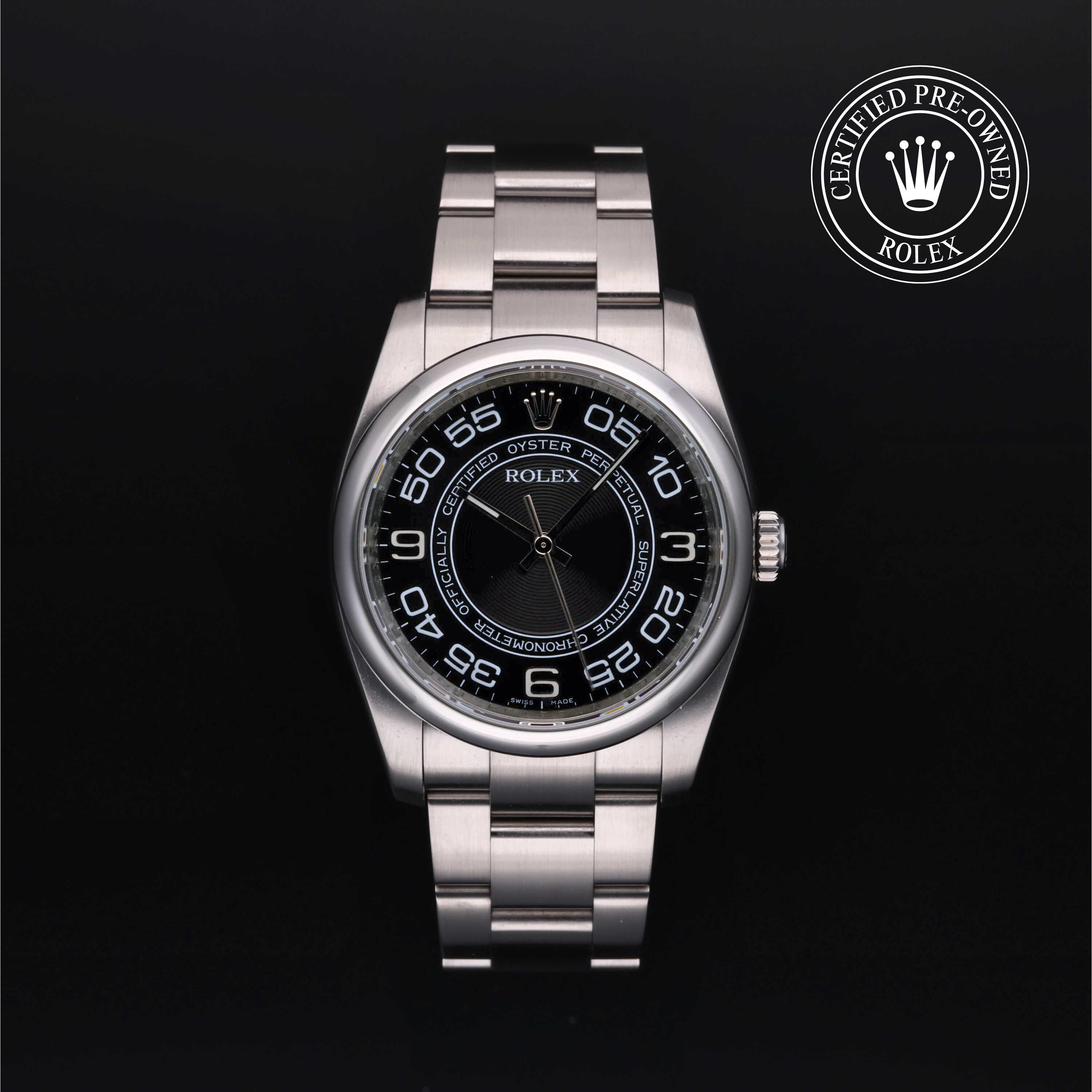A Rolex Oyster Perpetual watch with a stainless steel bracelet and a black dial featuring white Arabic numerals, shown against a black background with a 'Certified Pre-Owned Rolex' emblem in the top right corner.