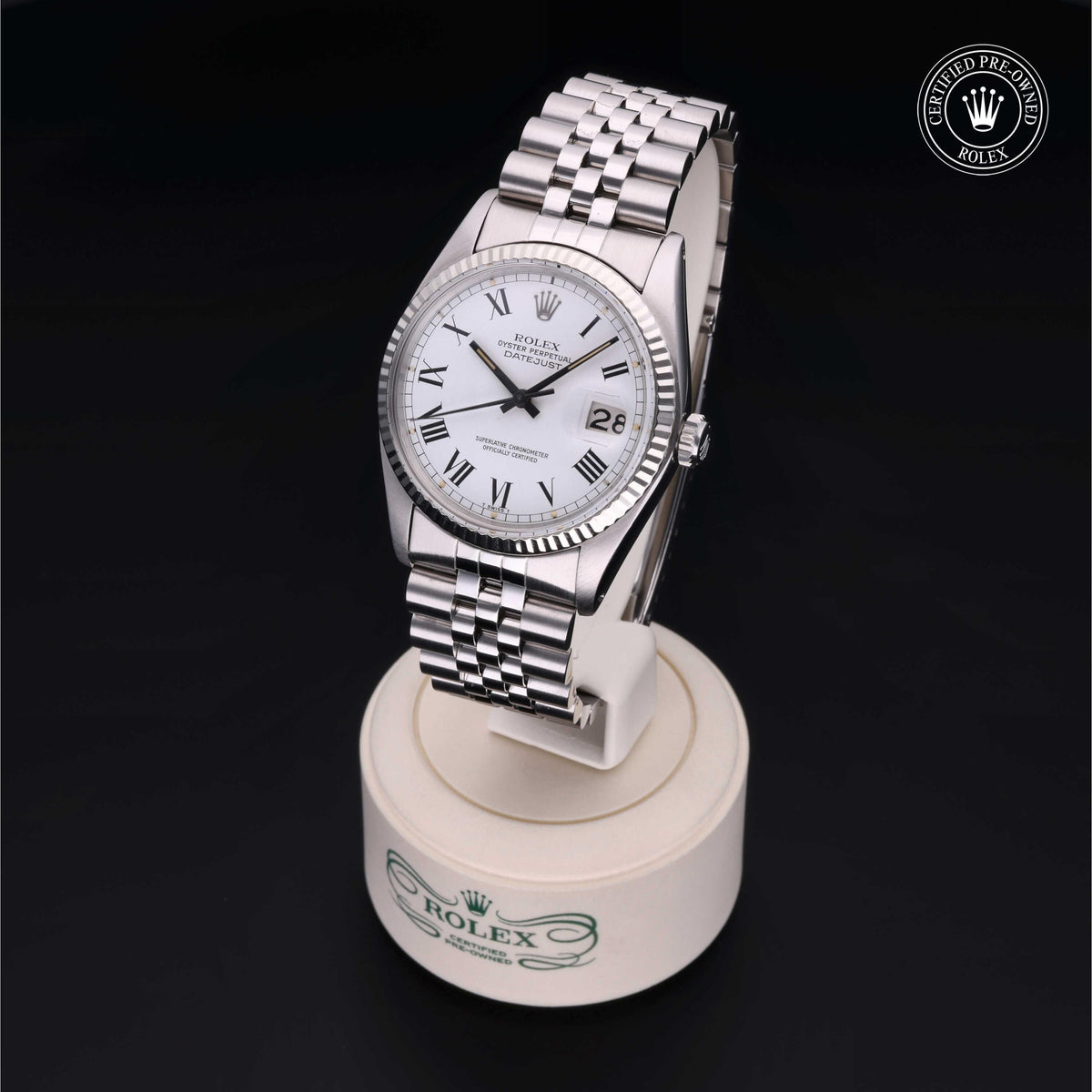 Luxury Rolex stainless steel wristwatch with white dial, Roman numerals, date window, and Jubilee bracelet displayed on branded stand with Certified Pre-Owned Rolex emblem in background.