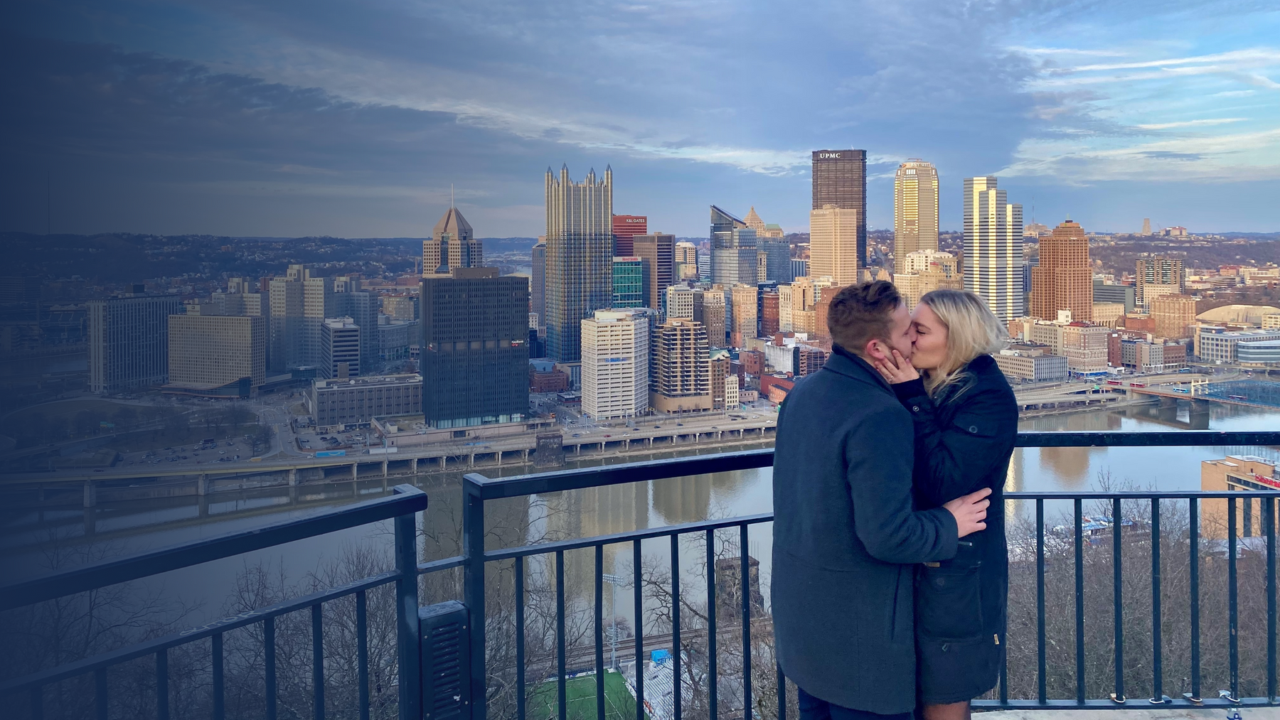 Henne couple Marc and Lisa overlooking Pittsburgh kissing